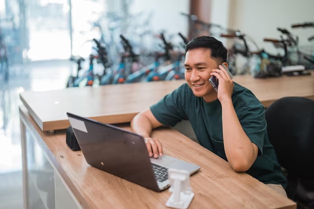 Business owner working on a laptop while speaking on the phone